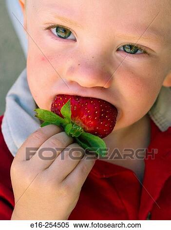 Stock Photography - child eating strawberry. Fotosearch