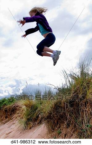 child girl jumping from sand dune View Large Photo Image Stock Image - child girl jumping from sand dune. Fotosearch
