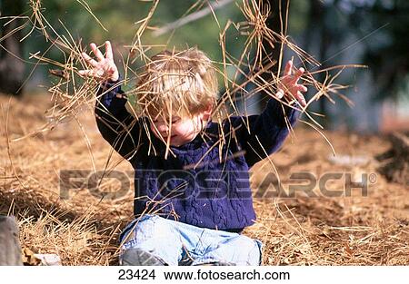 Picture - Child playing in pine needles. Fotosearch