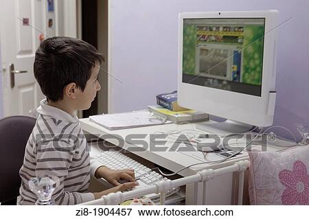 Stock Photo - Child plays computer games at home. Fotosearch