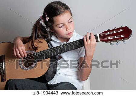 Stock Image - Child plays the guitar. Fotosearch
