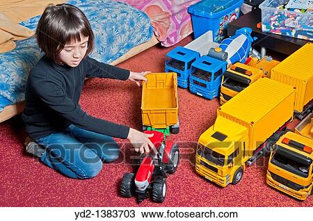 child plays with toy trucks and tractors View Large Photo Image Stock Image - child plays with toy trucks and tractors. Fotosearch