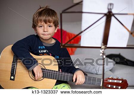 Stock Photo - Child rehearsing with guitar. Fotosearch