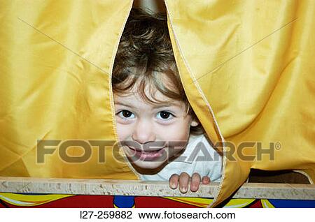 Child showing part of his face from behind a puppet curtain View Large Photo Image Stock Image - Child showing part of his face from behind a puppet curtain. Fotosearch