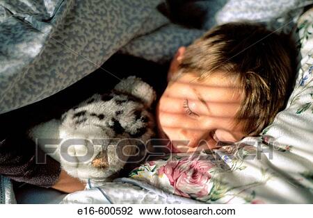 Stock Image - Child sleeping with stuffed animal. Fotosearch