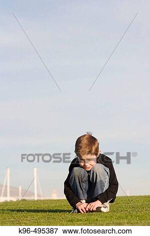 Stock Photo - child squating and grass. Fotosearch