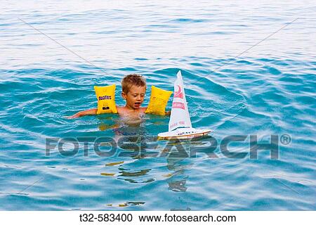 child swimming and plaing with swim arm safe View Large Photo Image Stock Image - child swimming and plaing with swim arm safe. Fotosearch
