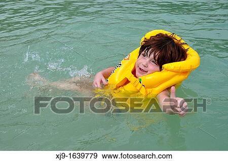 Stock Photo - Child swimming with life jacket. Fotosearch