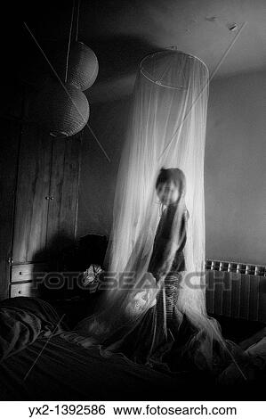 Stock Photograph - Child under a mosquito net. Fotosearch