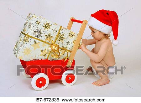 Child wearing Father Christmas hat with presents and gifts View Large Photo Image Stock Photograph - Child wearing Father Christmas hat with presents and gifts. Fotosearch