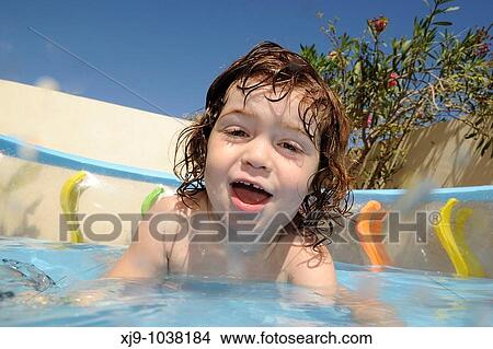 Child who can swim in the pool in the garden. View Large Photo Image Picture - Child who can swim in the pool in the garden.. Fotosearch