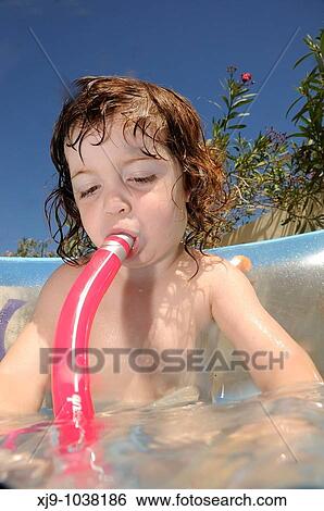 Stock Photograph - Child who can swim in the pool in the garden.. Fotosearch