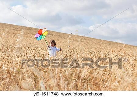 Stock Photo - child with a pinwheel in the field. Fotosearch