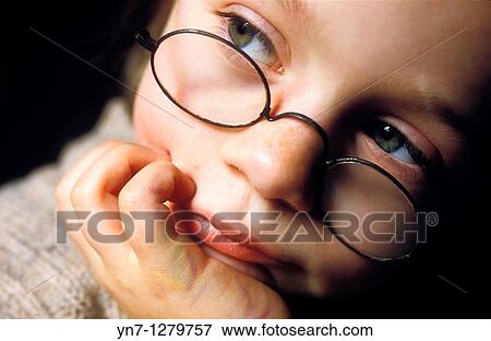 Stock Photo - child with glasses looking pensive. Fotosearch