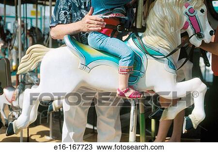 Child with parent at carousel View Large Photo Image Stock Image - Child with parent at carousel. Fotosearch