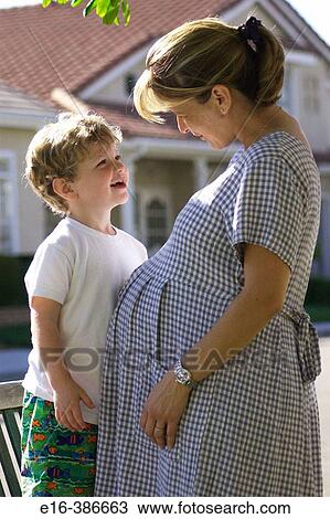 Stock Image - Child with pregnant mother. Fotosearch