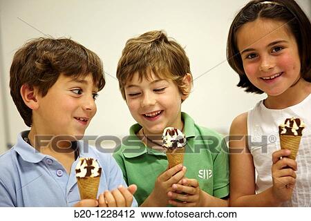 Stock Image - Children eating ice-cream cones, tasting session in sensory lab, AZTI-Tecnalia Marine and Food Research Center, Derio, Bizkaia, Euskadi, Spain. Fotosearch