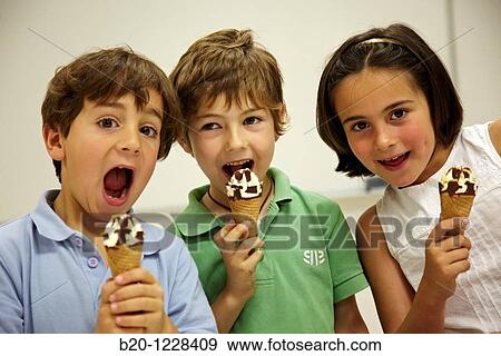 Stock Photo - Children eating ice-cream cones, tasting session in sensory lab, AZTI-Tecnalia Marine and Food Research Center, Derio, Bizkaia, Euskadi, Spain. Fotosearch