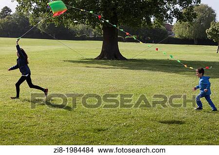 Children flying a kite in the park. View Large Photo Image Picture - Children flying a kite in the park.. Fotosearch
