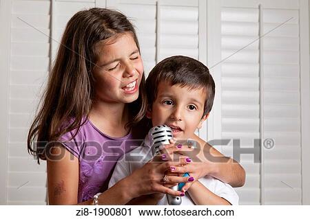 Stock Image - Children having fun on Karaoke. Fotosearch