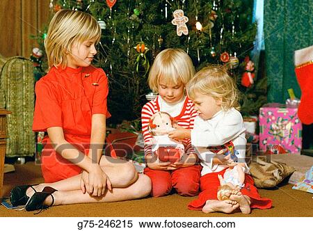 Stock Photography - Children in front of Christmas tree. Fotosearch