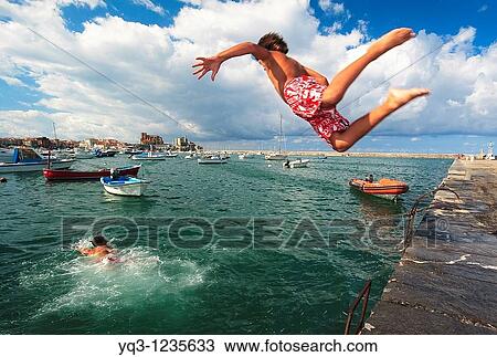 Children jumping in water at Muelle Don Luis. Castro Urdiales Bay, Cantabria, Spain. View Large Photo Image Stock Image - Children jumping in water at Muelle Don Luis. Castro Urdiales Bay, Cantabria, Spain.. Fotosearch