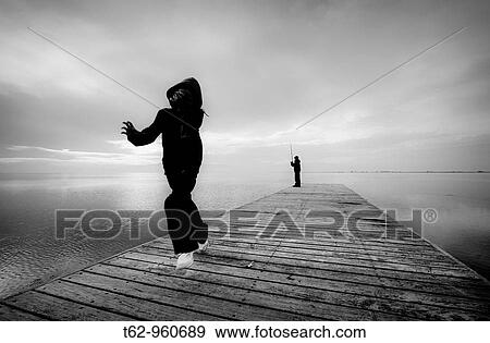 Stock Photo - Children playing and fishing on the pier Delta del Ebro Catalonia. Fotosearch