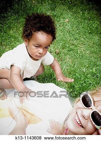 Stock Photo - children playing and sunbathing. Fotosearch