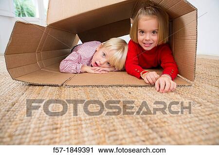 Stock Image - Children playing in a cardboard box. Fotosearch