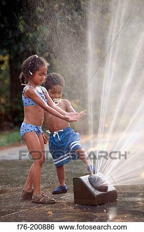 Children playing in sprinkler View Large Photo Image Stock Photograph - Children playing in sprinkler. Fotosearch