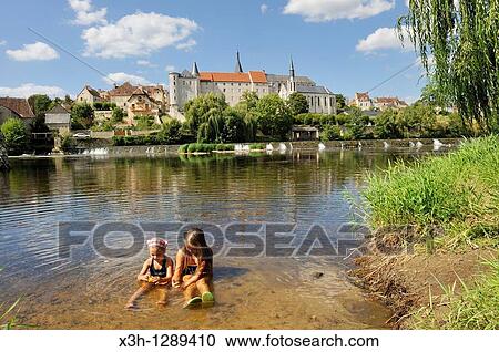 Stock Image - children playing in the river, Saint-Gaultier city on the Creuse river bank, Indre department, province of Berry, region of Centre, France, Europe. Fotosearch