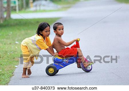 Stock Image - Children playing on the street at Bako Village, Sarawak, Malaysia.. Fotosearch