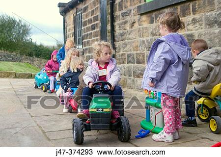 Children playing outside at nursrey school-lining up to pretend to put petrol in their toy cars View Large Photo Image Stock Image - Children playing outside at nursrey school-lining up to pretend to put petrol in their toy cars. Fotosearch