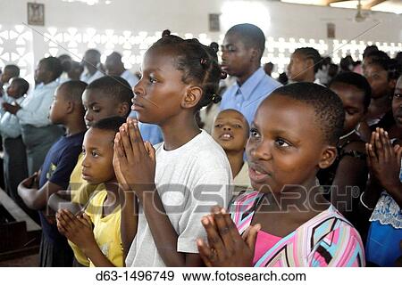 Children praying, Sunday mass at the Roman Catholic Parish of Buza, Dar es Salaam, Tanzania View Large Photo Image Stock Photo - Children praying, Sunday mass at the Roman Catholic Parish of Buza, Dar es Salaam, Tanzania. Fotosearch