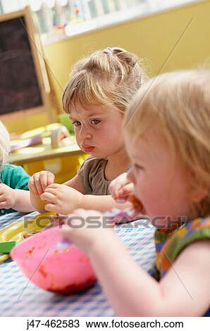 Children sitting eating lunch at nursery. View Large Photo Image Stock Image - Children sitting eating lunch at nursery.. Fotosearch