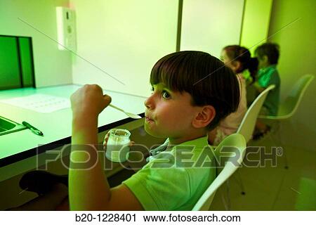 Stock Image - Children tutored by a sensory analysis specialist during a yoghurt tasting session with green lights to disguise the yoghurt colour, AZTI-Tecnalia Marine and Food Research Center, Derio, Bizkaia, Euskadi, Spain. Fotosearch