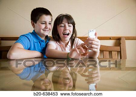Children using cell phone View Large Photo Image Stock Image - Children using cell phone. Fotosearch