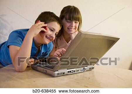 Children using portable computer and cell phone View Large Photo Image Stock Photography - Children using portable computer and cell phone. Fotosearch