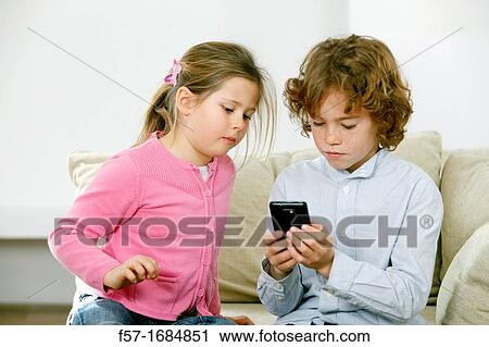 Stock Image - Children using smartphone. Fotosearch