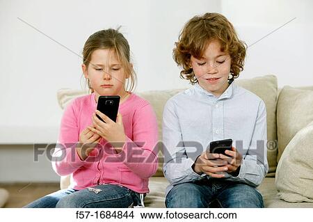 Picture - Children using smartphones. Fotosearch