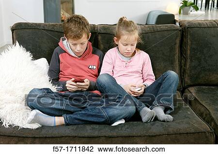 Stock Image - Children using smartphones. Fotosearch
