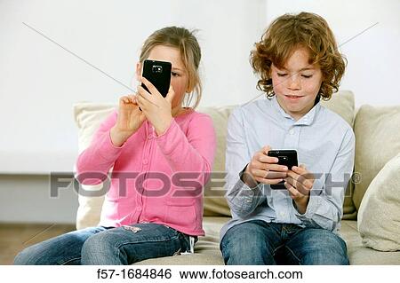 Stock Photograph - Children using smartphones. Fotosearch