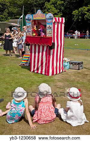 Stock Photo - Children watch a traditional Punch and Judy show, Nutley Fete, Sussex, England. Fotosearch