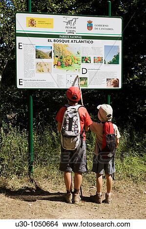 Picture - Children watching a poster about the forest, in a route in Li? bana valley Picos De Europa National Park Cantabria Spain. Fotosearch