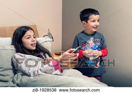 Children watching TV in bed View Large Photo Image Stock Photo - Children watching TV in bed. Fotosearch
