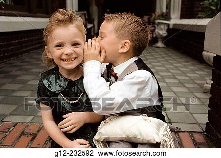 Children whisper to each other as they prepare to be ring bearers at a wedding View Large Photo Image Stock Image - Children whisper to each other as they prepare to be ring bearers at a wedding. Fotosearch