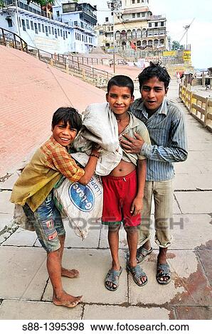 Stock Photo - Children who pick up plastic bottle to sell at the ghat by the Ganges river. Fotosearch