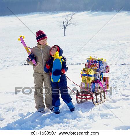 Children with Christmas presents on sledge in snow View Large Photo Image Stock Photo - Children with Christmas presents on sledge in snow. Fotosearch