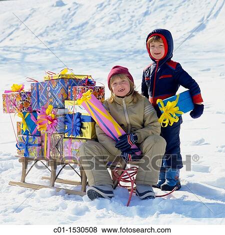Children with Christmas presents on sledge in snow View Large Photo Image Stock Photo - Children with Christmas presents on sledge in snow. Fotosearch