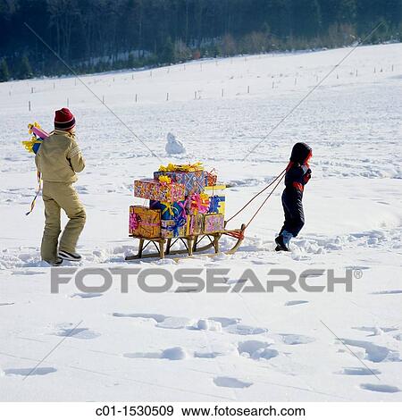 Children with Christmas presents on sledge in snow View Large Photo Image Stock Photo - Children with Christmas presents on sledge in snow. Fotosearch